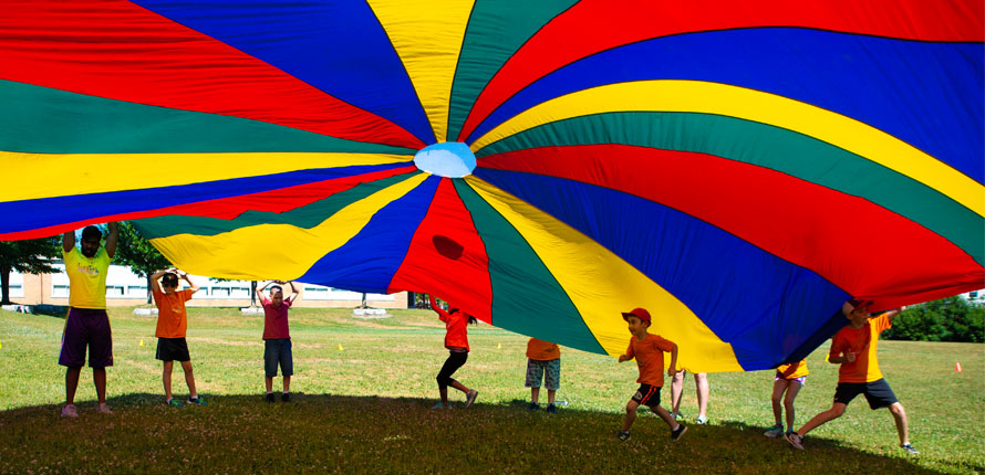 kids playing under a parachute