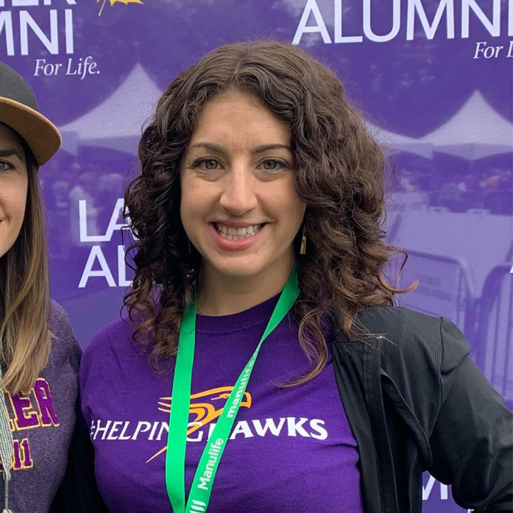 Laura Crochetiere smiles at the camera. She is wearing a Laurier Helping Hawks shirt.