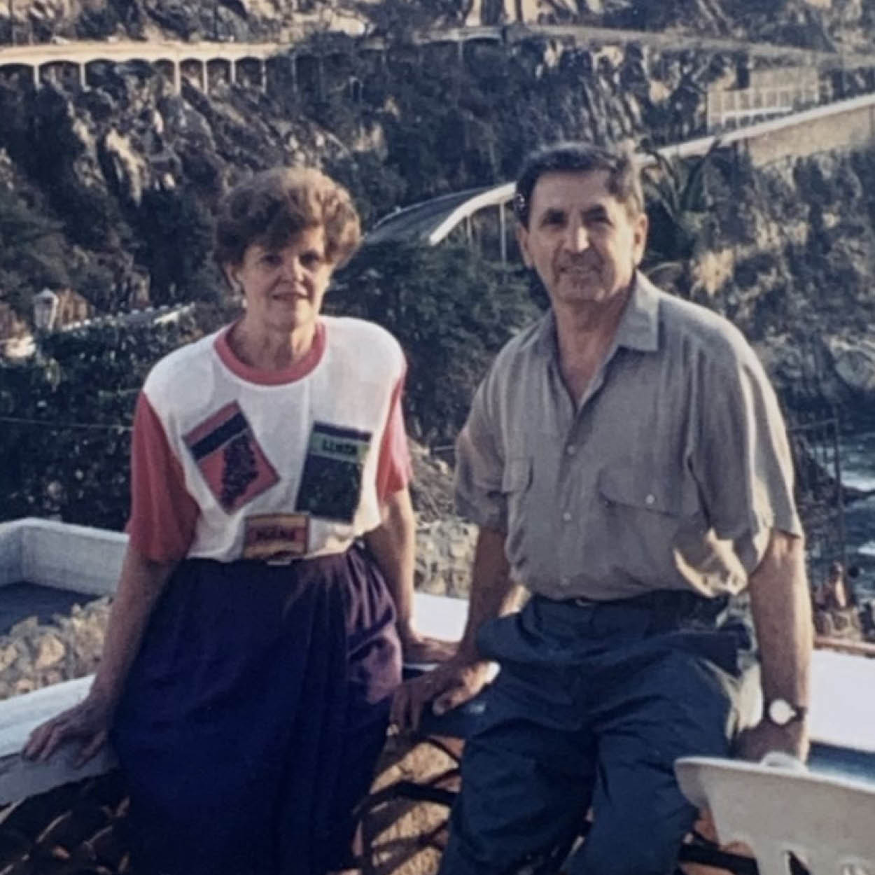 Vince and Doreen Saccucci pose in front of a scenic view of sunny cliffs.
