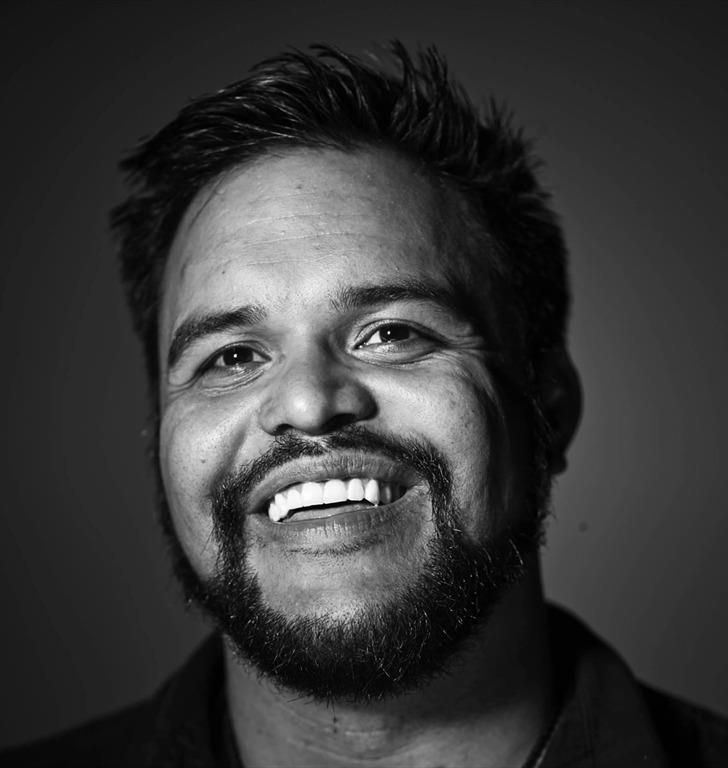 black-and-white portrait of Ravi Srinivasan smiling warmly into the camera