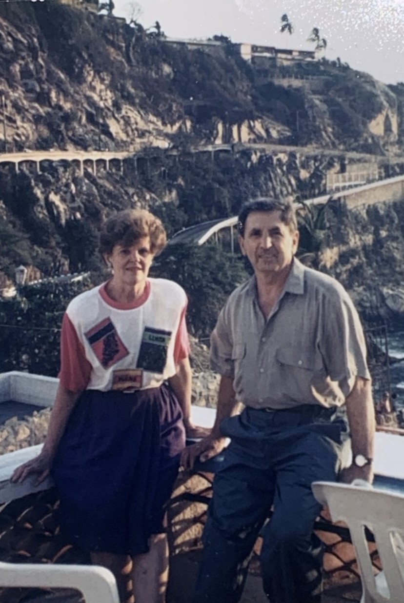 Vince and Doreen Saccucci pose in front of a scenic view of cliffs and roads.