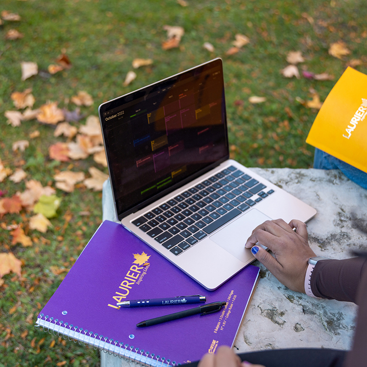 Spotlight story image pertaining to image of a laptop with Laurier-branded notebooks.