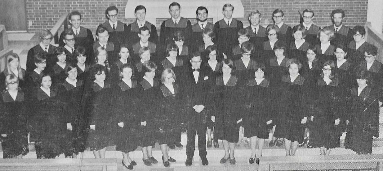 A choir posed at the front of a church, wearing robes.