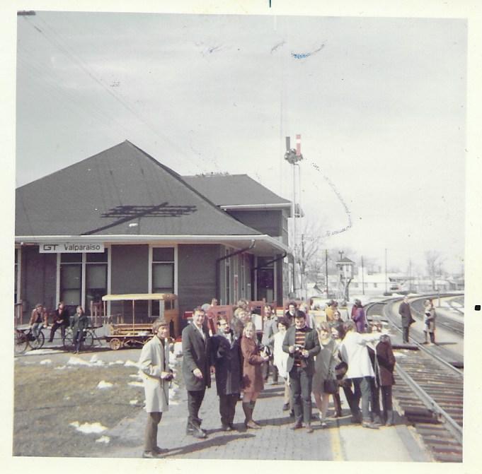 Approximately 20 young people in front of a small train station, with a sign that says "Valparaiso".